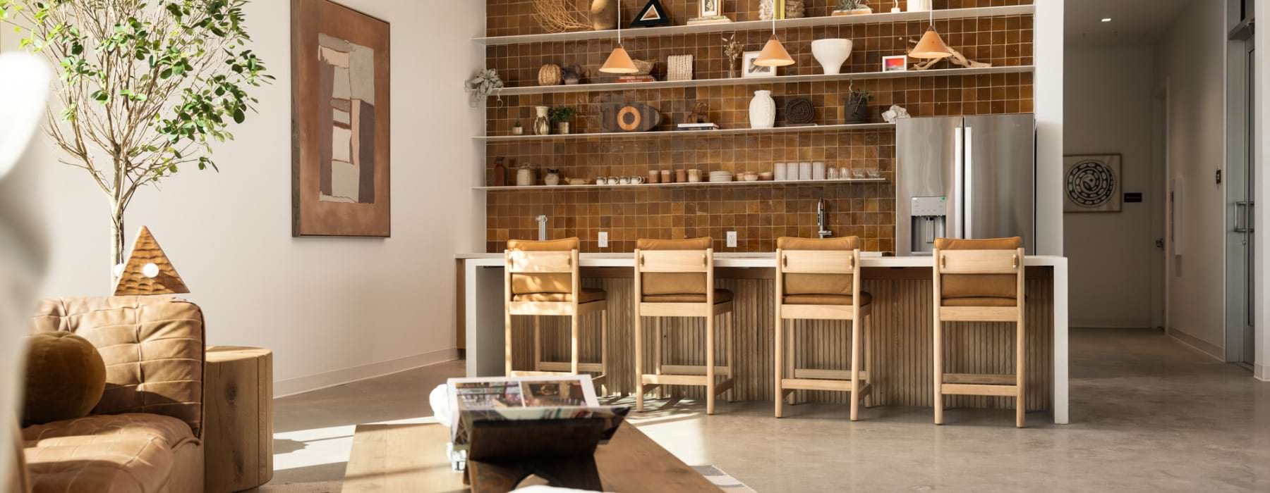 A clubroom with high top chairs, lounge couch, and table